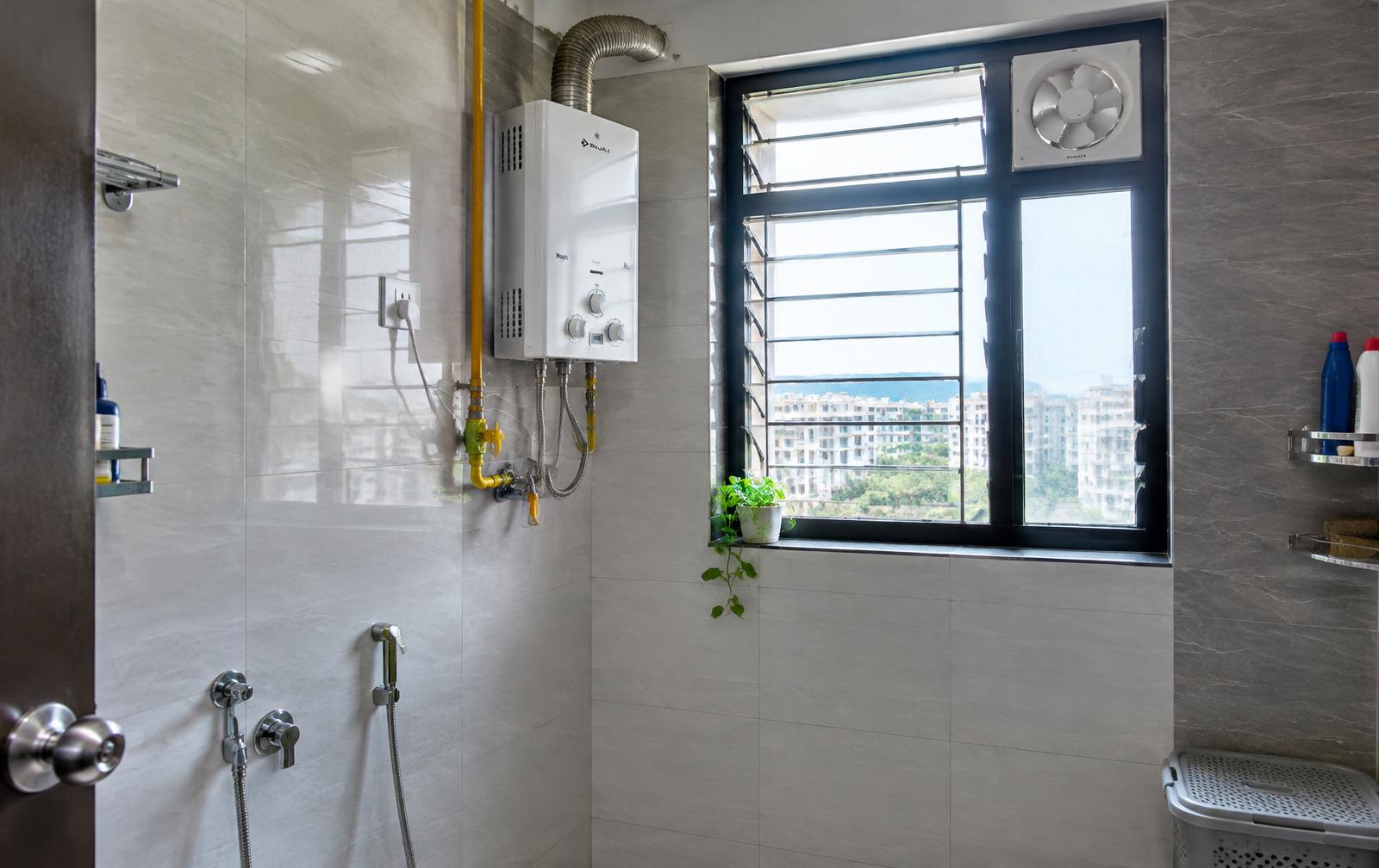 Wall-mounted gas geyser installed in a ventilated bathroom of an Indian apartment